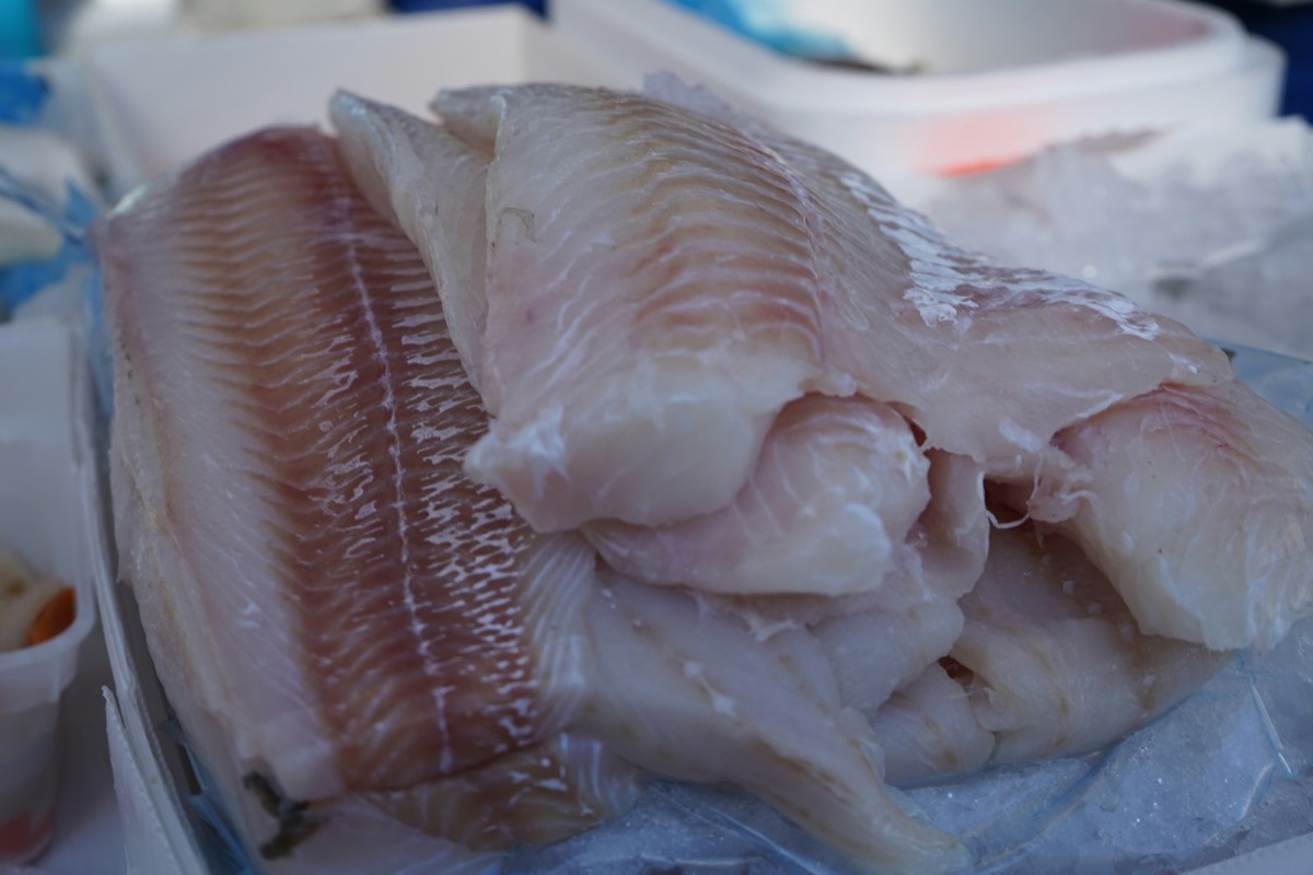 Raw white fish fillets on ice at a market stall